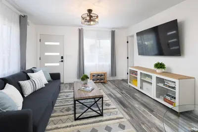 a living room with a couch and a tv at 3 Bed House with Fire Pit Table and BBQ - Downtown in San Diego