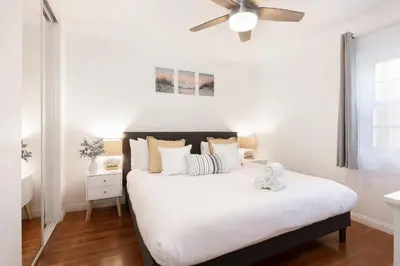 a bedroom with a bed with a ceiling fan at 2 Bedroom - Ocean View Hot Tub Parking - 8 Guest in San Diego