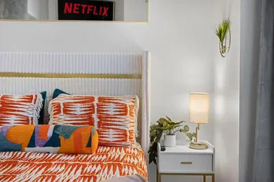 a bedroom with a bed with orange and blue pillows at Park Lux PlayHouse in San Diego