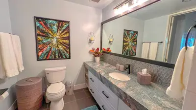 a bathroom with a toilet and a large mirror at Italyhaus in San Diego