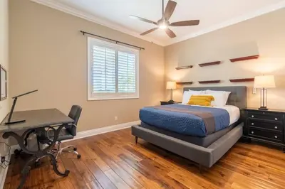 a bedroom with a bed and a desk and a ceiling fan at Temecula Wine Country Villa in Temecula