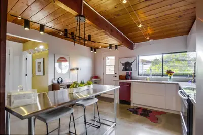 a kitchen with a long counter and a dining table at Avoyer One Bedroom Guesthouse - La Mesa in La Mesa