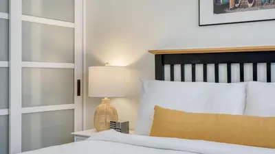 a bedroom with a bed and a lamp on a table at Surfrider I by AvantStay Walk to the Beach Patio in Newport Beach