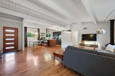 a living room with a couch and a table and a kitchen at Agua Dulce - Mid Century Oasis - Pool &Hot Tub in Spring Valley