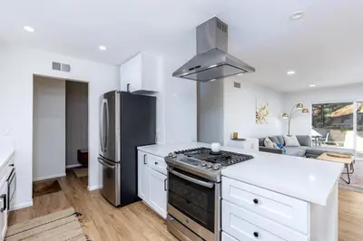 a kitchen with white cabinets and a stainless steel refrigerator at Echo by Coast to Cactus - Family-Friendly Home in La Mesa