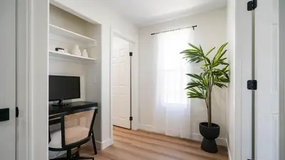 a living room with a tv and a potted plant at The Oliver - Pacific Beach Hideaway in San Diego