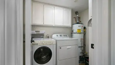 a laundry room with a washing machine and white cabinets at The Oliver - Pacific Beach Hideaway in San Diego