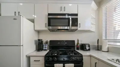 a kitchen with a stove and a microwave at The Oliver - Pacific Beach Hideaway in San Diego