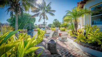 a garden with palm trees and a building at Mediterranean-Style Villa in Point Loma in San Diego