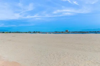 a sandy beach with a blue sky and the ocean at Bayside Retreat in San Diego