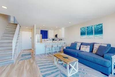 a living room with a blue couch and a kitchen at Bayside Retreat in San Diego