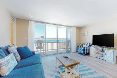 a living room with a blue couch and a flat screen tv at Bayside Retreat in San Diego