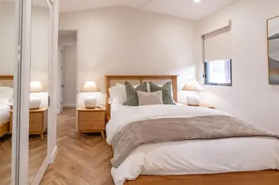 a white bedroom with a large bed and two lamps at Enchanting Encinitas Oceanview Casita in Encinitas