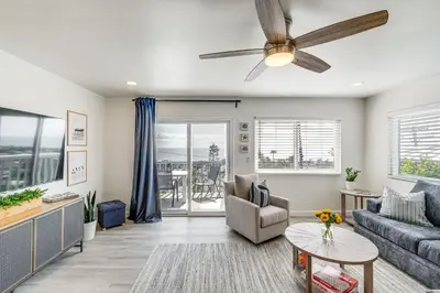 a living room with a couch and a ceiling fan at Cardiff Retreat with Game Room and Deck, Near Beach in Cardiff-by-the-Sea