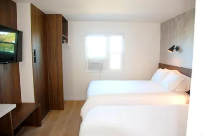 a hotel room with two beds and a television at Uptown Inn - Limited Service Apart-Hotel in San Diego