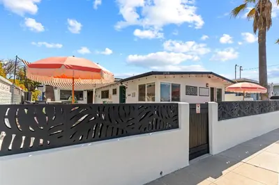 a fence with an umbrella in front of a restaurant at Amazing Place by the Sea - O'side Palms in Oceanside