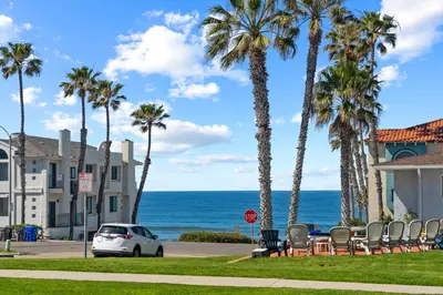 a car parked on a street with palm trees and the ocean at Amazing Place by the Sea - O'side Palms in Oceanside