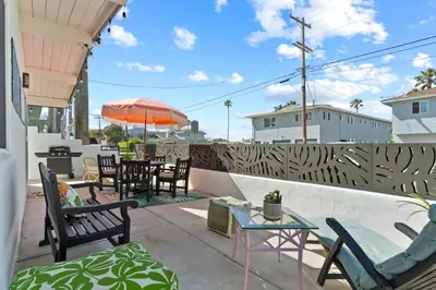 a patio with chairs and tables and an umbrella at California Dreamin at O'side Palms in Oceanside