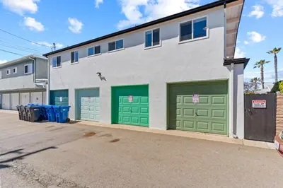 a building with green garage doors on a street at Day in Paradise at Oside Palms in Oceanside