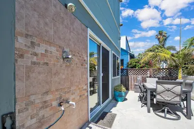a house with a patio with a table and chairs at Stunning Beach Haven! Steps to the Beach & Pet Friendly! in San Diego