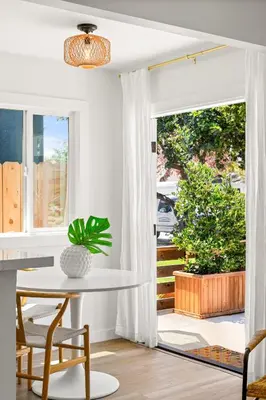 a white dining room with a table and a window at Modern and Cozy in PB with Patio and Firepit in San Diego