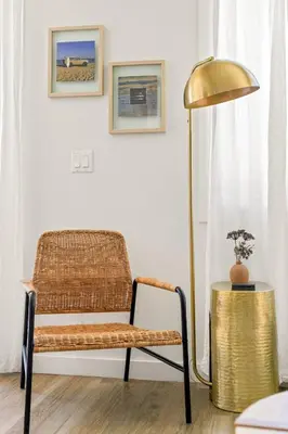 a gold lamp next to a rattan chair next to a table at Modern and Cozy in PB with Patio and Firepit in San Diego