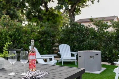 a bottle of wine sitting on a table with two wine glasses at Modern and Cozy in PB with Patio and Firepit in San Diego