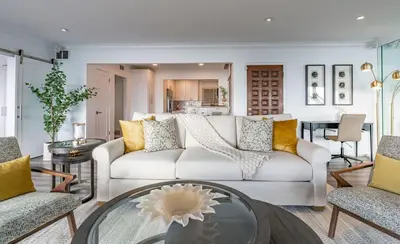 a living room with a white couch and a table at Oceanfront Townhome with Breathtaking Views in San Diego