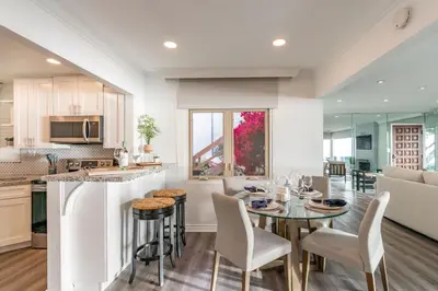 a kitchen and living room with a table and chairs at Oceanfront Townhome with Breathtaking Views in San Diego
