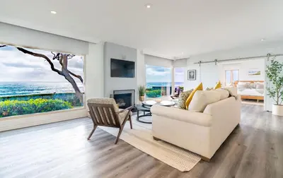 a living room with a white couch and a fireplace at Oceanfront Townhome with Breathtaking Views in San Diego