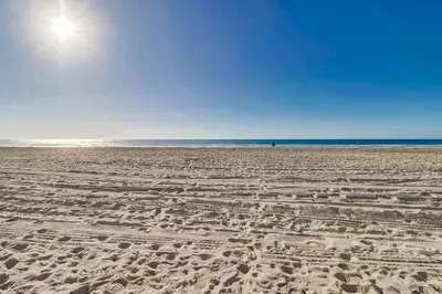a sandy beach with the ocean in the background at Breezy Bayside Cottage in San Diego