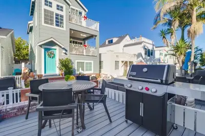 a patio with a grill and a table and chairs at Breezy Bayside Cottage in San Diego