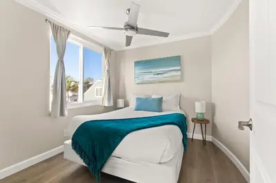 a white bedroom with a bed and a window at Prime Mission Beach Getaway in San Diego