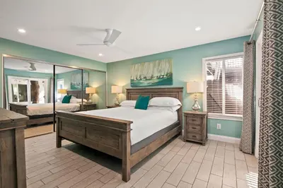 a bedroom with a large bed and a mirror at Coastal Chic at Windansea in San Diego