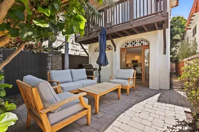 a patio with a bunch of chairs and an umbrella at Coastal Chic at Windansea in San Diego