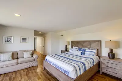 a bedroom with a bed and a couch at Massive Beach Home with Ocean View & Amazing Rooftop in San Diego