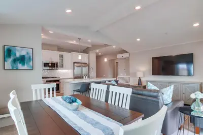a kitchen and living room with a dining room and a table at Newly Built Bayside Dream, Fire Pit & Bay Views in San Diego