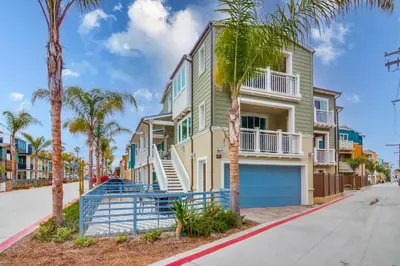 a row of palm trees in front of a building at Newly Built Bayside Dream, Fire Pit & Bay Views in San Diego