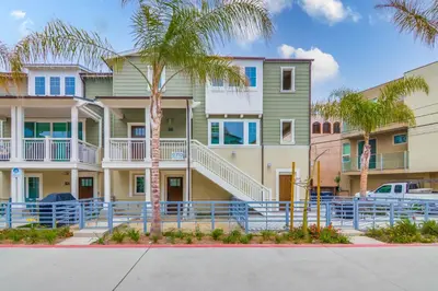 a building with palm trees in front of it at Newly Built Bayside Dream, Fire Pit & Bay Views in San Diego