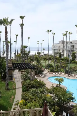 a view of the pool and beach from the balcony of a resort at Oceanside Beach Condos in Oceanside