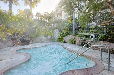a small swimming pool in a yard with trees at Oceanside Beach Condos in Oceanside