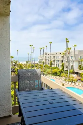a table and chairs on the balcony of a resort at Oceanside Beach Condos in Oceanside