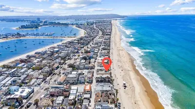 an aerial view of a beach and the ocean at Luxury Ground S Oceanfront Unit with Boardwalk Lounge Firepit - AC in San Diego