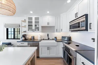 a white kitchen with a sink and a microwave at N Oceanfront Masterpiece with Rooftop & Hot Tub in San Diego