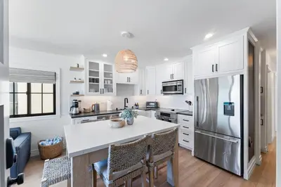 a kitchen with white cabinets and a refrigerator at N Oceanfront Masterpiece with Rooftop & Hot Tub in San Diego