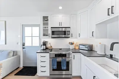 a kitchen with white cabinets and a stove top oven at Entire Ground Beachfront Luxury Unit with Patio in San Diego
