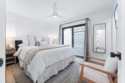 a white bedroom with a large bed and a window at Entire Ground Beachfront Luxury Unit with Patio in San Diego