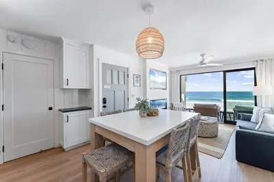 a kitchen and living room with a table and chairs at Luxury oceanfront fourplex with roof deck sleeps 22 in San Diego