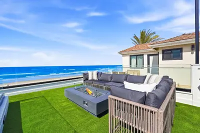 a living room with a couch and a fire pit at Luxury oceanfront fourplex with roof deck sleeps 22 in San Diego