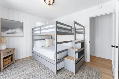 a bedroom with a bunk bed and a mirror at Luxury oceanfront fourplex with roof deck sleeps 22 in San Diego